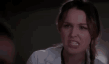 a close up of a woman in a white lab coat looking at the camera .