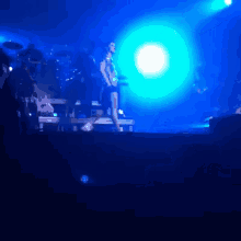 a woman singing on a stage with blue lights