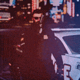 a police officer is standing next to a police car with the letter p on it