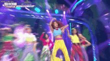 a group of people are dancing on a stage with the words show champion on the bottom right