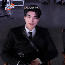 a man in a suit and tie is sitting in front of a sign that says ' pisode ' on it