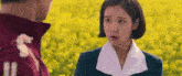 a man and a woman are standing next to each other in a field of yellow flowers .