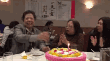 a woman blows out a birthday candle on a cake
