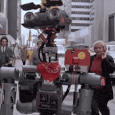 a robot with a red bandana around its neck has a smiley face on it