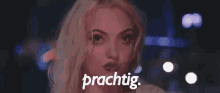 a woman with pink hair is standing in front of a sign that says  prachtig .
