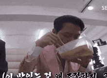 a man in a pink suit is drinking from a clear plastic container