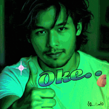 a man is giving a thumbs up with the word oke written on his shirt