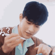 a young man is holding a pen in his hand and pointing at something .
