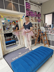 a man in a tutu is standing in front of a mirror with the words the dancers on the floor