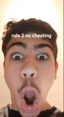 a man making a funny face with rule 2 no cheating written on the top