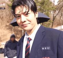 a man wearing a suit and tie has a name tag that says ' 박 류 인 ' on it