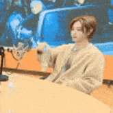 a woman is sitting at a table with a microphone in front of her .
