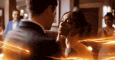 a man and a woman are kissing in a room with a lot of lights coming out of them .
