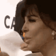 a close up of a woman 's face with a piece of paper in her mouth .