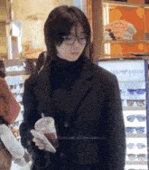 a woman wearing glasses stands in front of a montblanc display