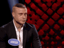 a man in a suit has a name tag that says adrian on it