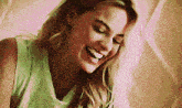 a woman in a green tank top is laughing