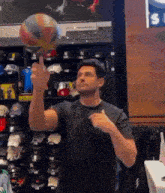 a man in a black shirt is holding a basketball in his hand .