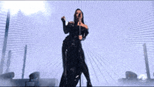 a woman singing into a microphone while standing on a stage