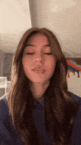 a woman with long brown hair is making a funny face .