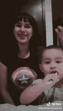 a woman is brushing a child 's teeth with a toothbrush