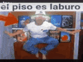 a man is jumping in the air with a sign that says el piso es laburo .