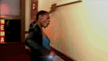 a man is standing in a hallway with a sign that says neena