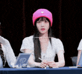 a girl wearing a pink beanie is sitting at a table with a sign that says triples