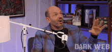 a man is sitting in front of a microphone and the words dark web are on the bottom