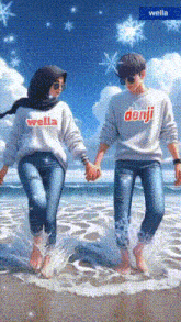a boy and a girl are holding hands on the beach and the boy is wearing a wella sweatshirt