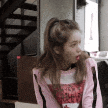 a girl wearing a pink sweater that says i love you