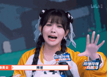 a girl with pigtails is wearing a yellow jacket and a microphone that says bilibili on it