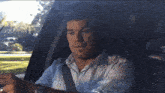 a man is sitting in a car looking at his watch