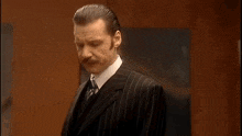 a man in a suit and tie says that he is the greatest man in the world