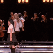 a group of people playing violins and cello on stage