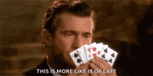 a man is holding a bunch of playing cards in his hand .