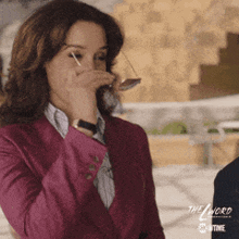 a woman in a pink suit is covering her mouth with glasses