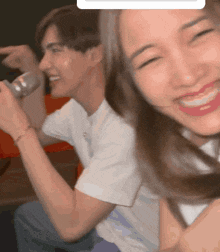 a man and a woman are sitting next to each other and the woman is smiling