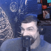 a man wearing headphones is talking into a microphone in front of a christmas tree