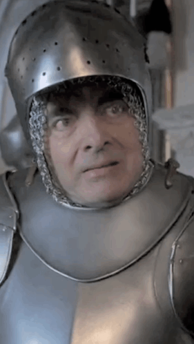 a man wearing a helmet and armor looks at the camera