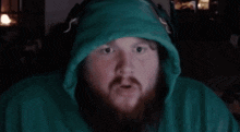 a man with a beard wearing a green hoodie