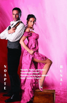 a woman in a pink dress stands next to a man in a black suit