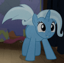 a blue pony with a horn and wings is standing on the floor