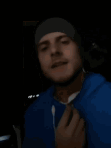 a man wearing a blue hoodie and a gray hat
