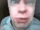 a close up of a man 's face with glasses on and a blurred background .