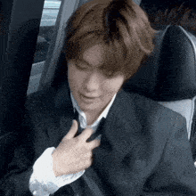 a man in a suit and tie is sitting in a car seat