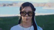 a woman wearing sunglasses has a reflection of herself in the lenses