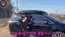 a man is getting out of a black minivan with korean writing on it