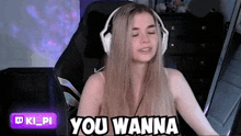 a woman wearing headphones is sitting in a chair and saying you wanna