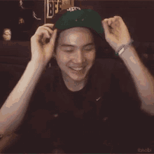 a man wearing a green hat and headphones is smiling